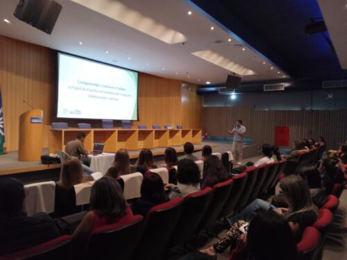 Auditório de palestra com palco de madeira. palestrante fala ao microfone