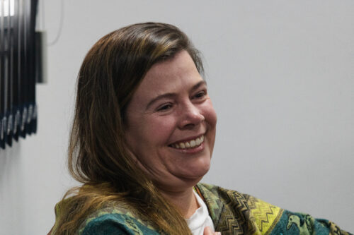 A imagem mostra uma mulher de perfil sorrindo.