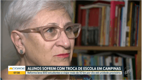 Captura de tela de computador que mostra uma reportagem. Há uma mulher branca, com cabelo curto e branco, olhos claros e usando óculos olhando para frente. O fundo atrás dela é uma estante com livros. Abaixo, há uma faixa horizontal com o texto "Alunos sofrem com troca de escola em Campinas" e, abaixo, há outra caixa de texto com o texto "Reforma leva 800 estudantes a viajar mais de 50 km por dia até unidade provisória". À direita, há o logotipo da EPTV. Fim da descrição.