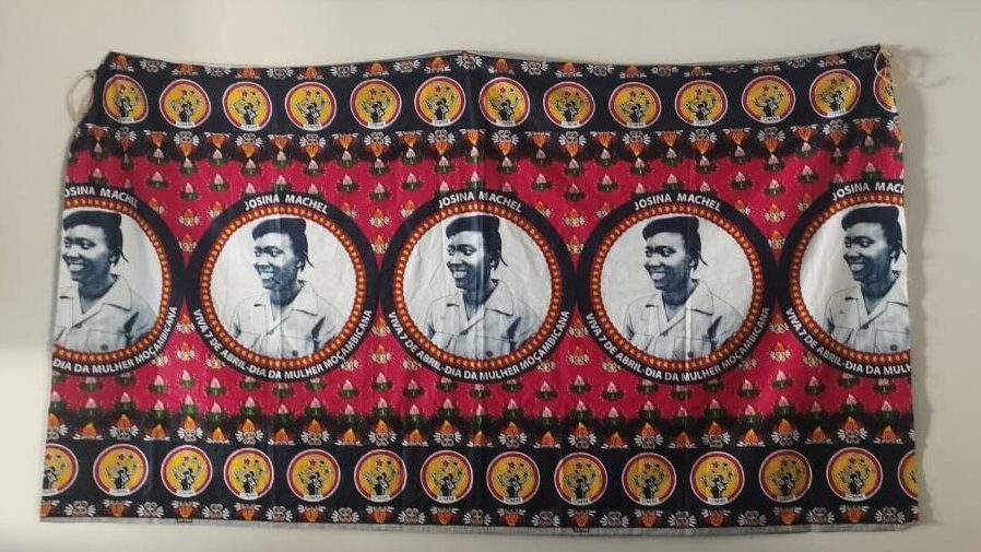 Fotografia que mostra tecido com estampas coloridas e com o rosto da guerrilheira Maria Lúcia Petit. O fundo é uma parede bege.