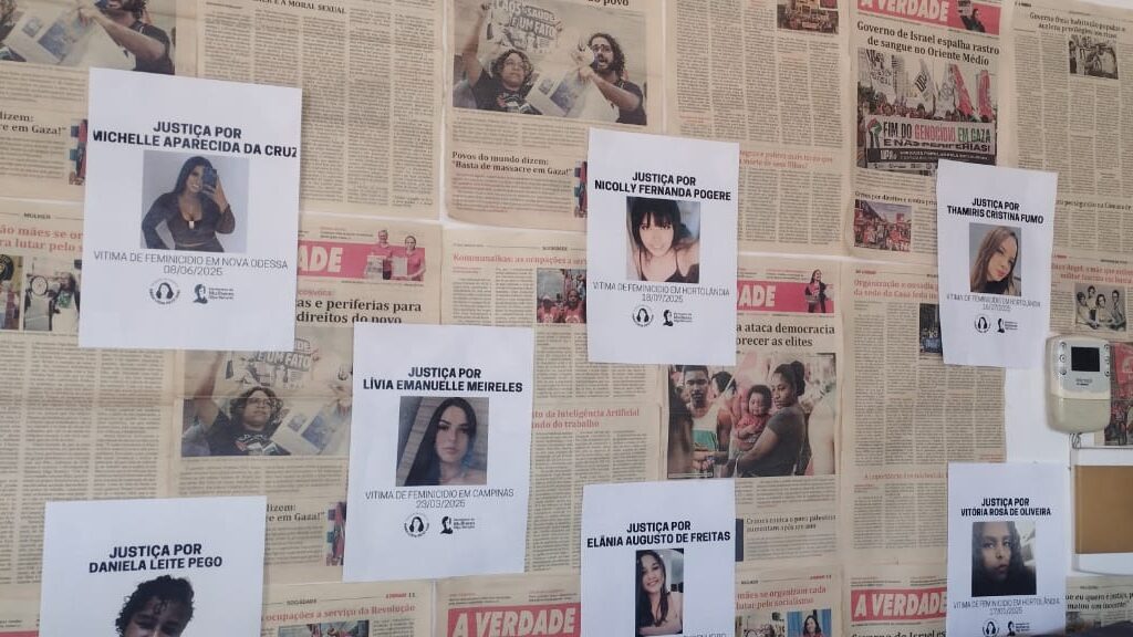 Fotografia que mostra mural composto por notícias de jornal e fotos de mulheres vítimas de feminicídio na cidade de Campinas. Fim da descrição.
